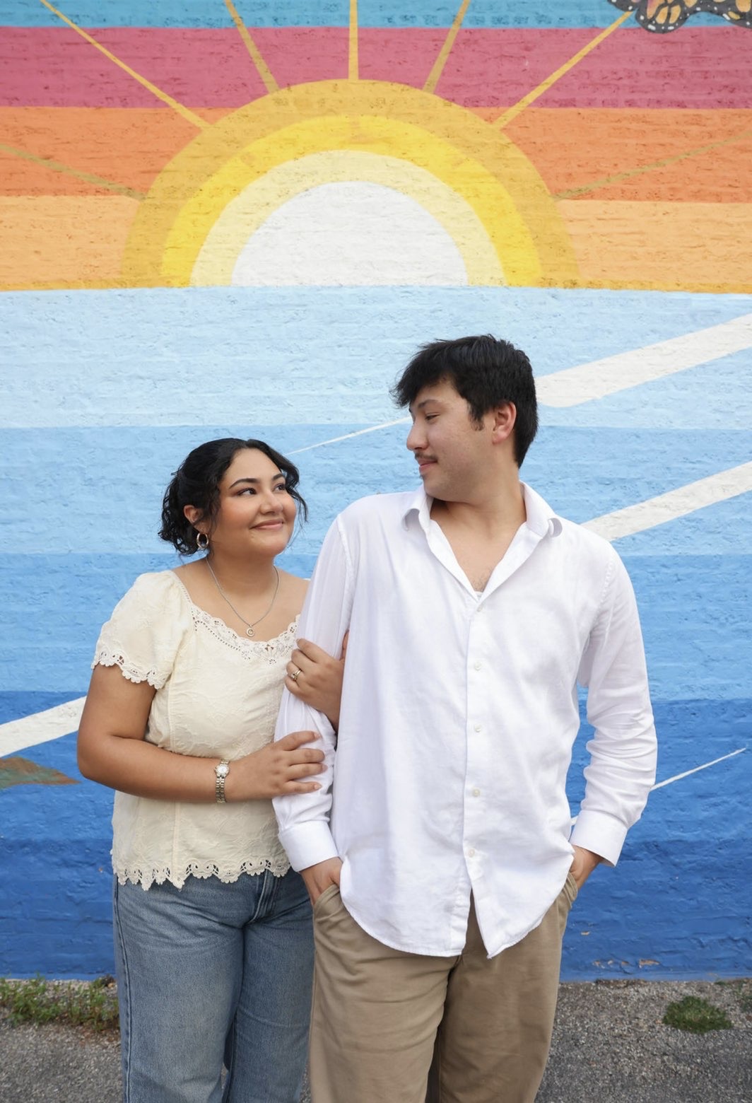 Ethan and Elli in front of a painted sunrise mural